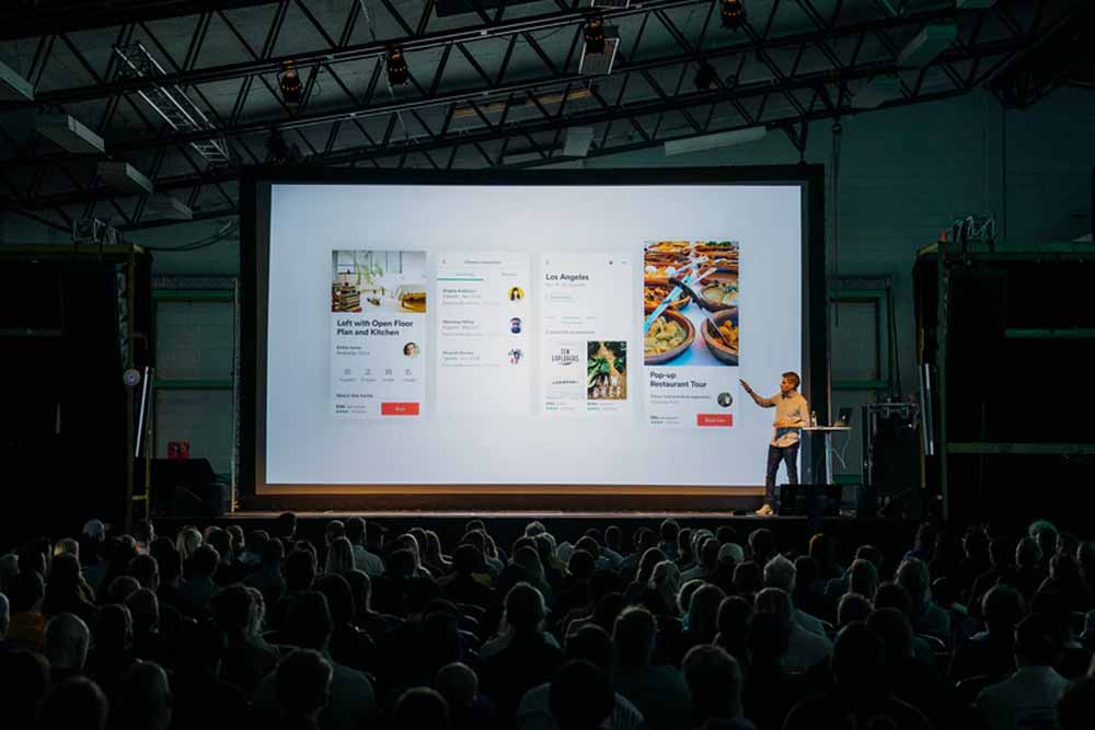 A Man showing food app Presentation in stage